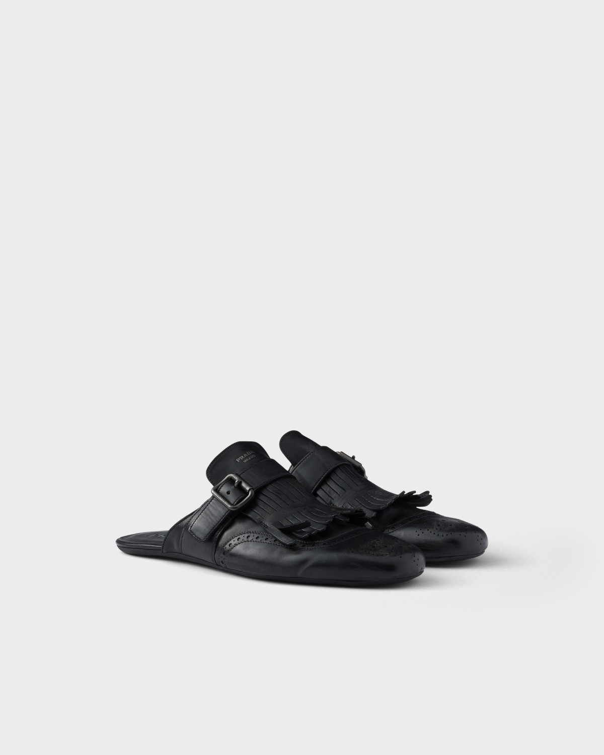 Prada Shuffle Antiqued Leather Mules With Buckled Strap And Fringe Black